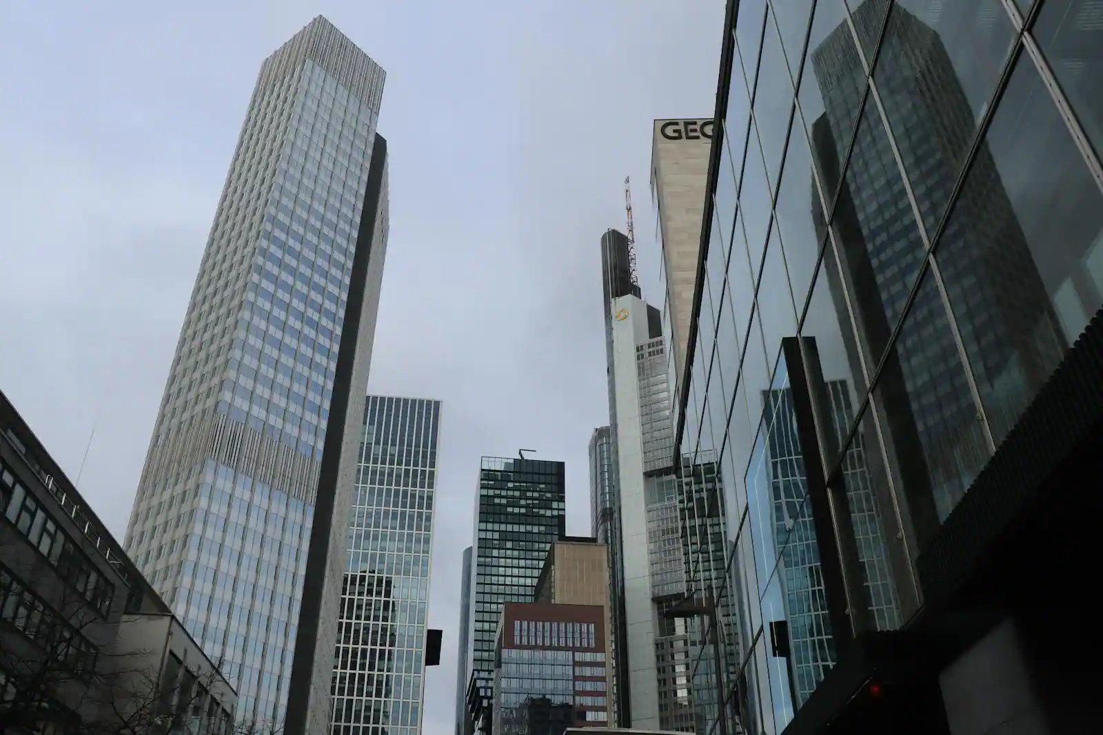 Gratte-ciel vitrés d'un quartier d'affaires moderne photographiés en contre-plongée sous un ciel couvert
