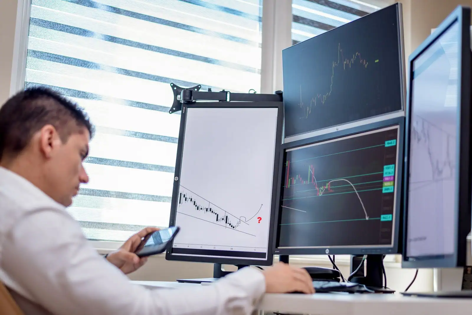 Investisseur analysant des graphiques boursiers et des indicateurs de marché sur un écran d'ordinateur