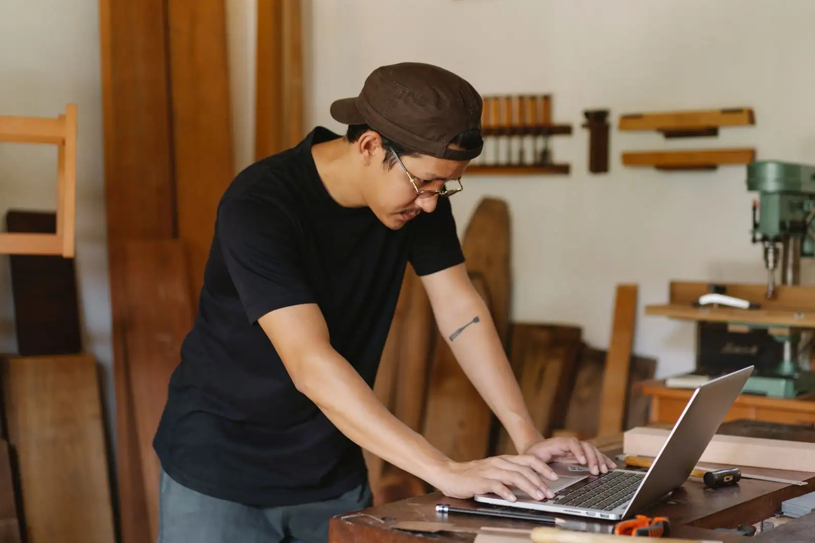 Un jeune entrepreneur travaille sur son ordinateur portable dans son petit atelier indépendant