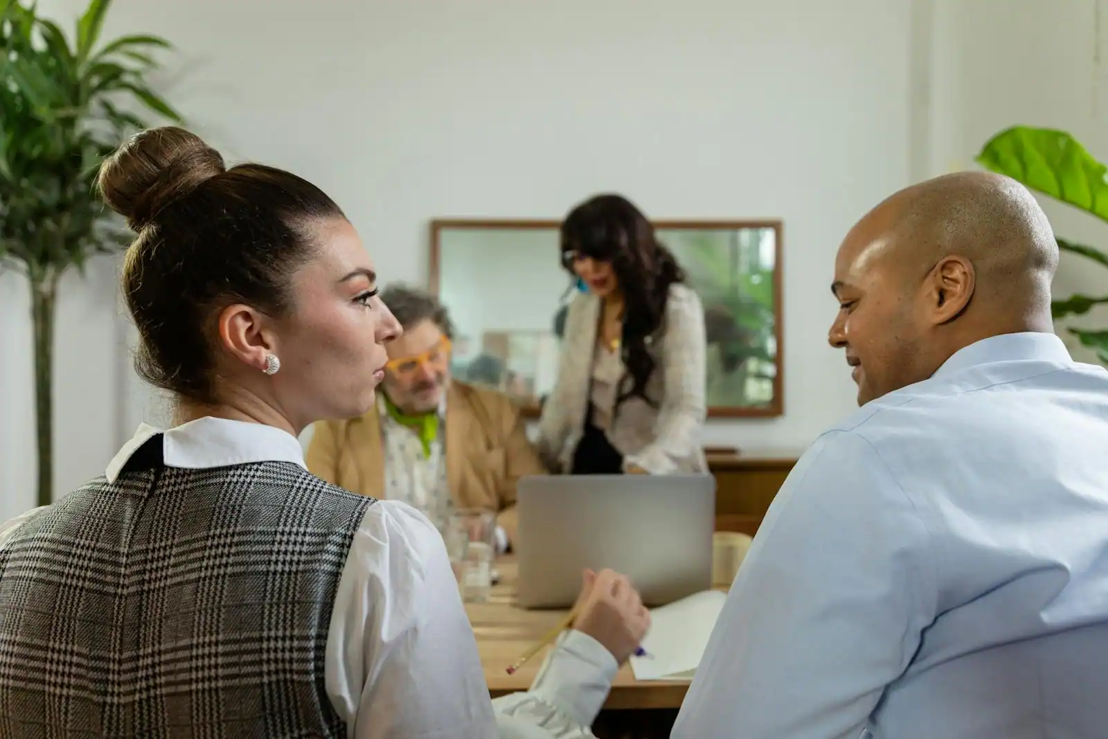 Plusieurs collègues en réunion dans un bureau lumineux, en pleine discussion de travail