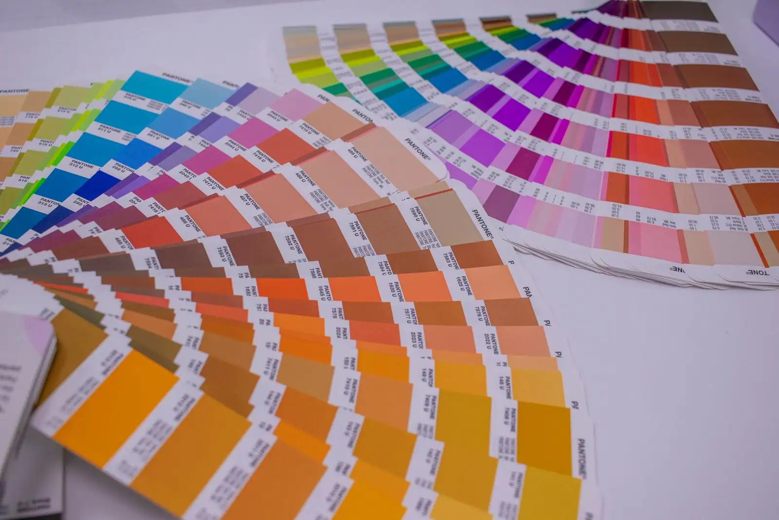 Nuanciers de couleurs déployés en éventail, illustrant le choix des couleurs en design graphique.