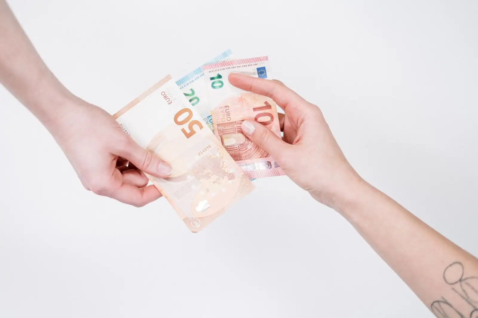 Deux mains échangeant des billets en euros sur un fond clair, illustrant une opération de change