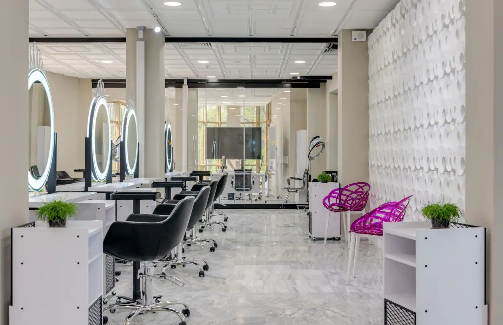 Intérieur lumineux d'un salon de coiffure avec fauteuils de coupe et miroirs ronds éclairés le long du mur.