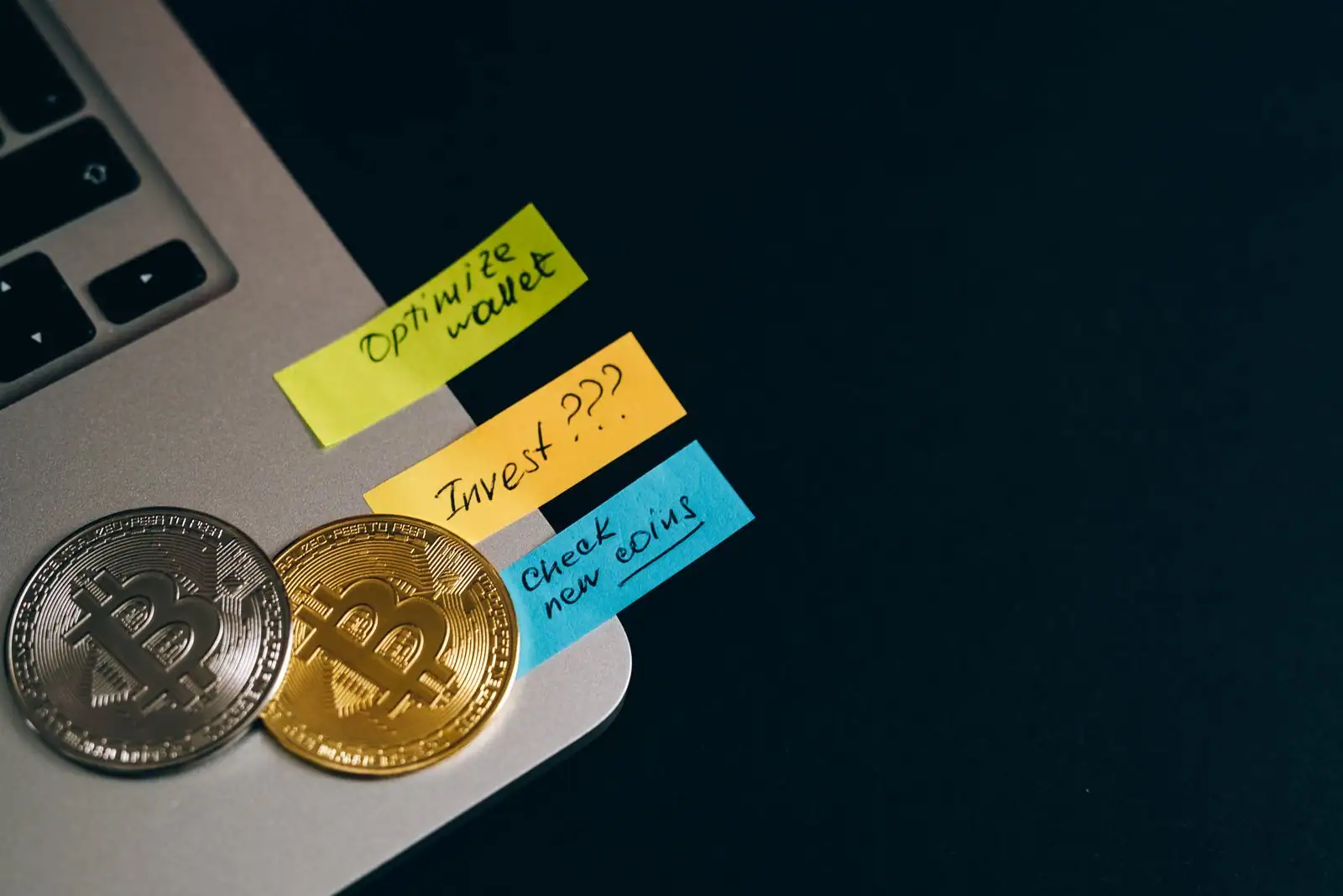 Deux pièces physiques symbolisant le bitcoin, posées sur un ordinateur portable