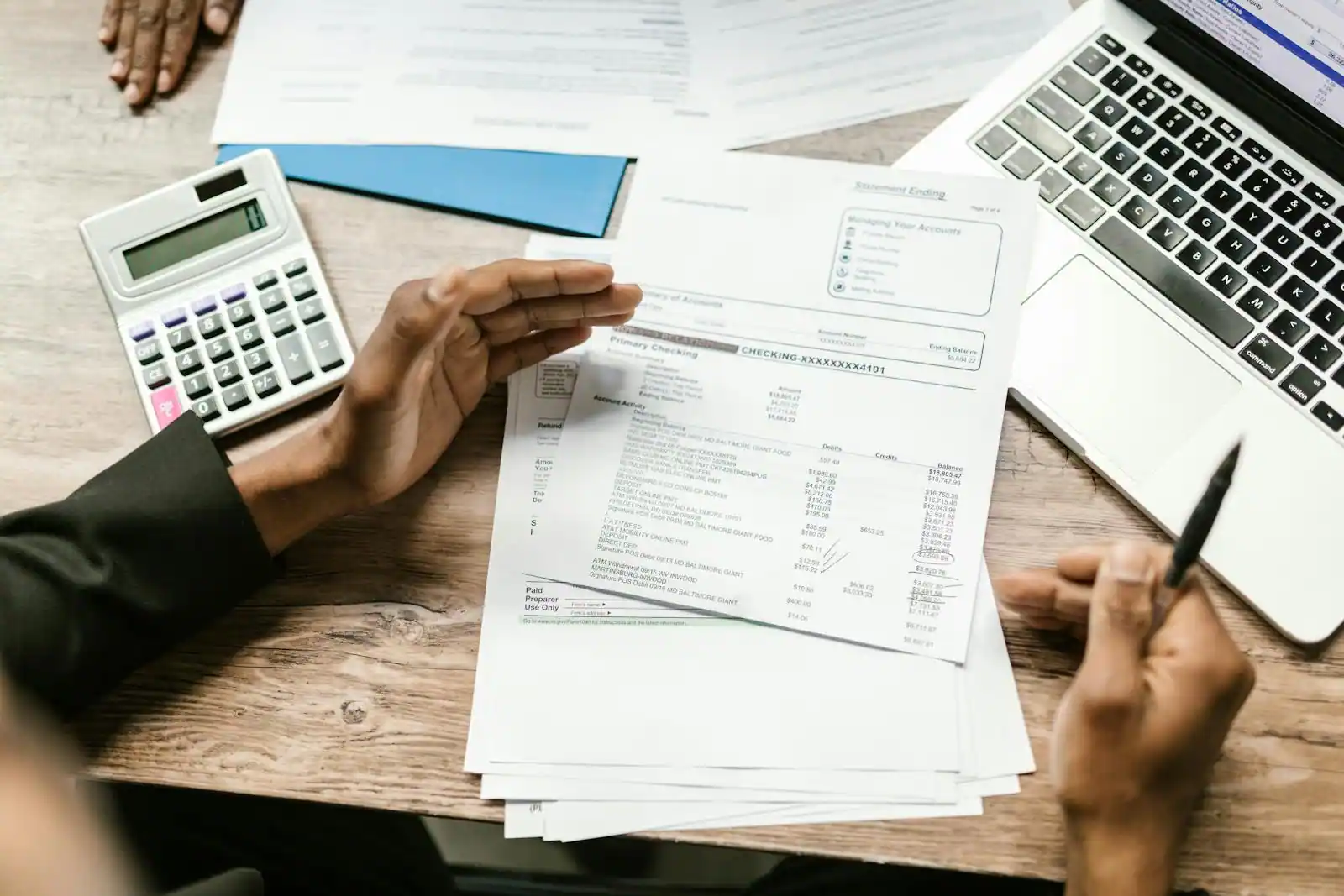Conseiller en gestion de patrimoine examinant des documents de placement et un portefeuille sur un bureau.