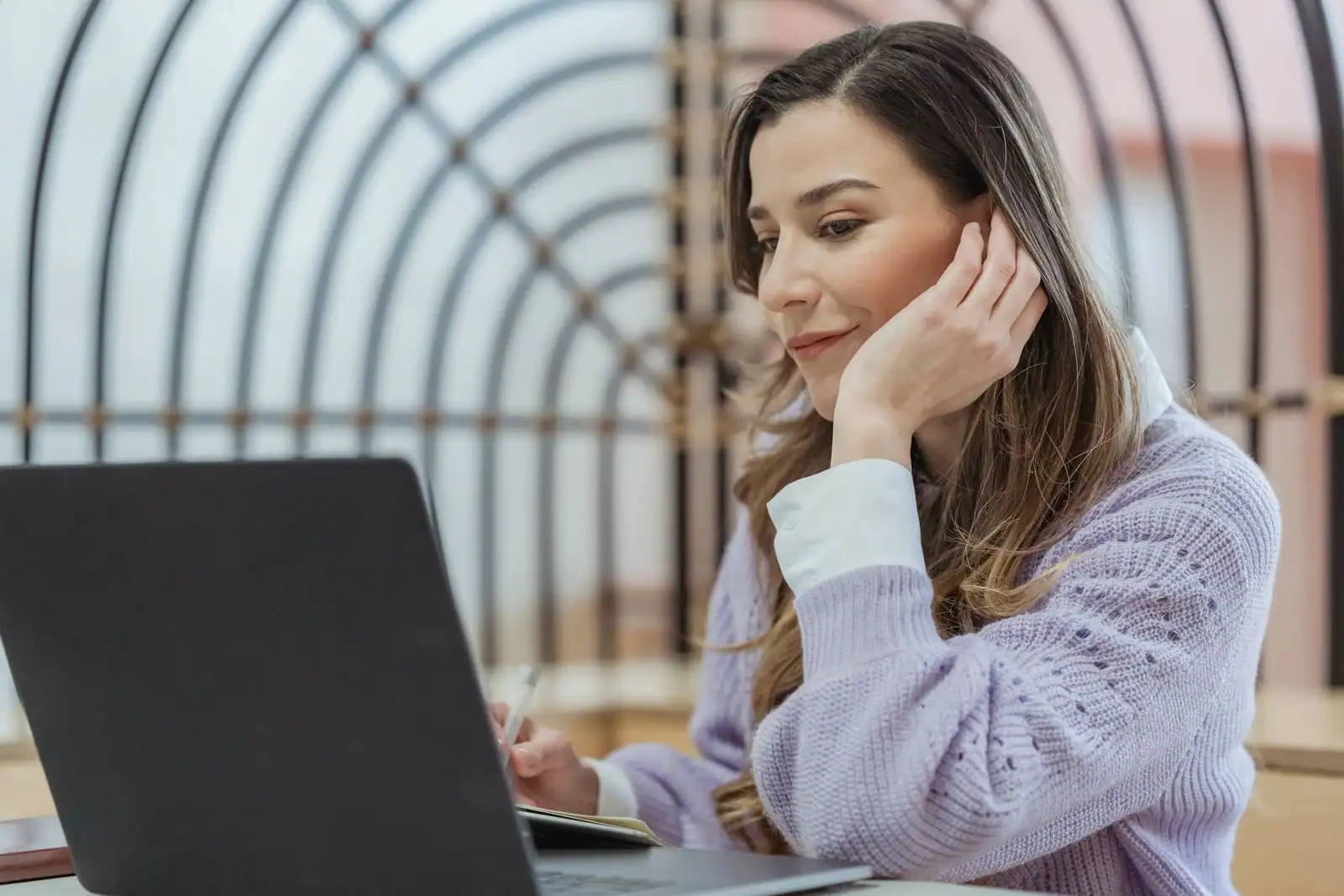 Étudiant rédigeant une lettre de motivation sur un ordinateur portable, un CV posé à côté sur le bureau