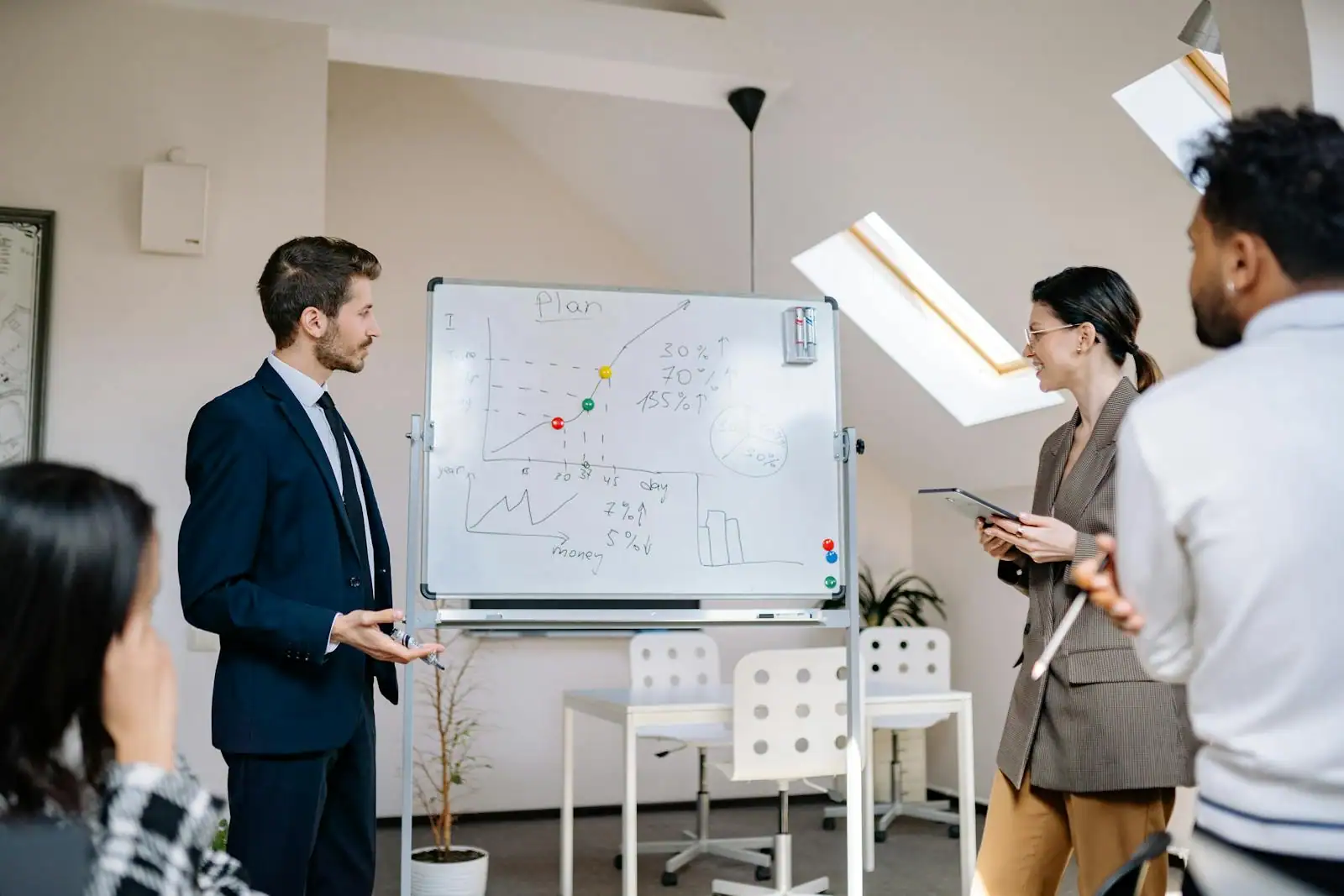 Équipe réunie autour d'un tableau de management visuel couvert de notes dans un bureau lumineux