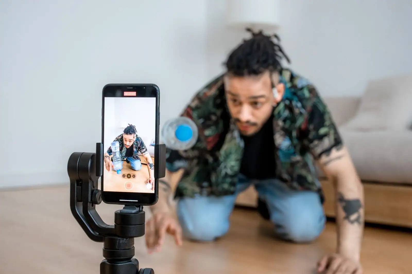 Créateur se filmant avec un smartphone monté sur un stabilisateur, dans un contexte de réseaux sociaux.