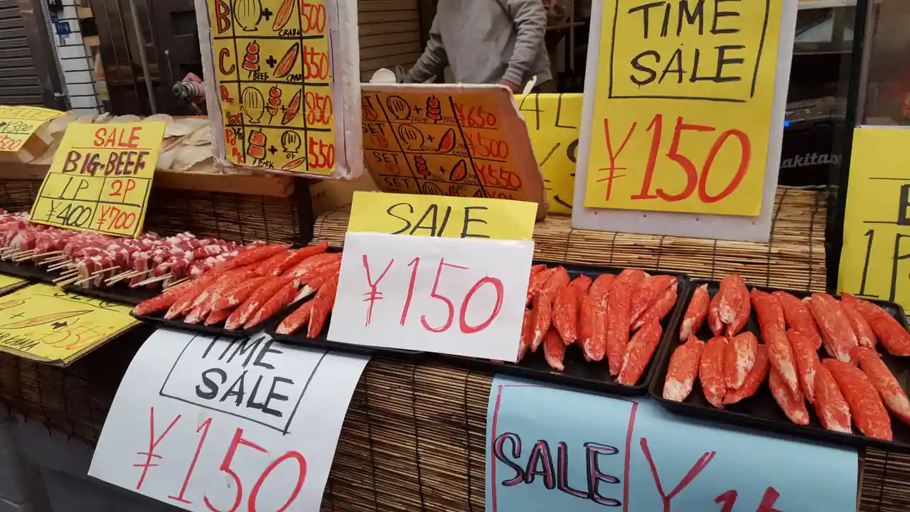 Étiquettes de prix en yens sur un étal de marché japonais, avec des montants affichés à 150 ¥