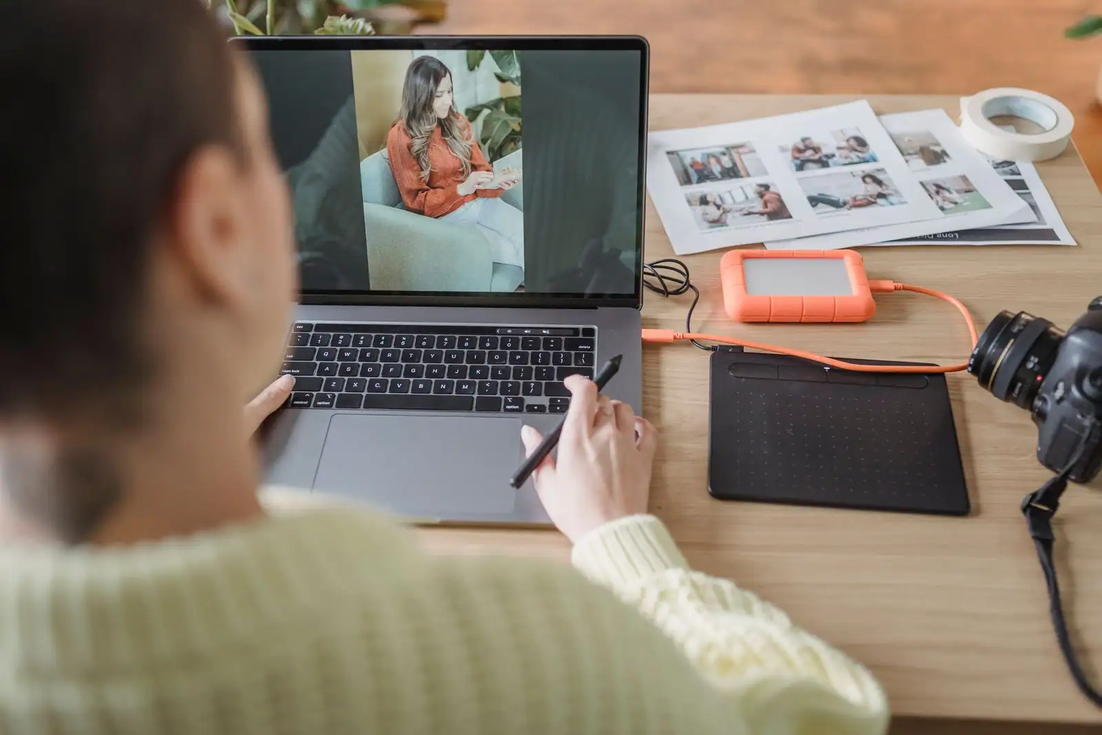 Retouche d’une photographie sur un ordinateur portable, stylet en main et tablette graphique posée à côté