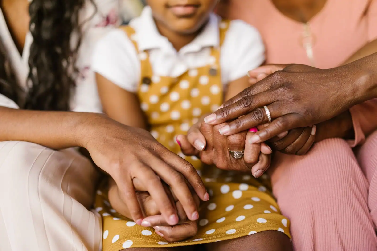 Mains de plusieurs générations jointes, image de la solidarité entre les âges que porte la Sécurité sociale.