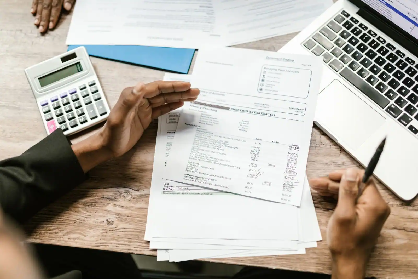 Dirigeant examinant des documents financiers avec une calculatrice sur un bureau clair