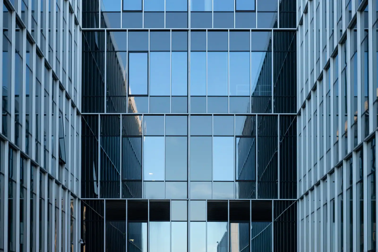 Facade d'immeuble moderne en verre et acier, illustrant l'univers des infrastructures du batiment.