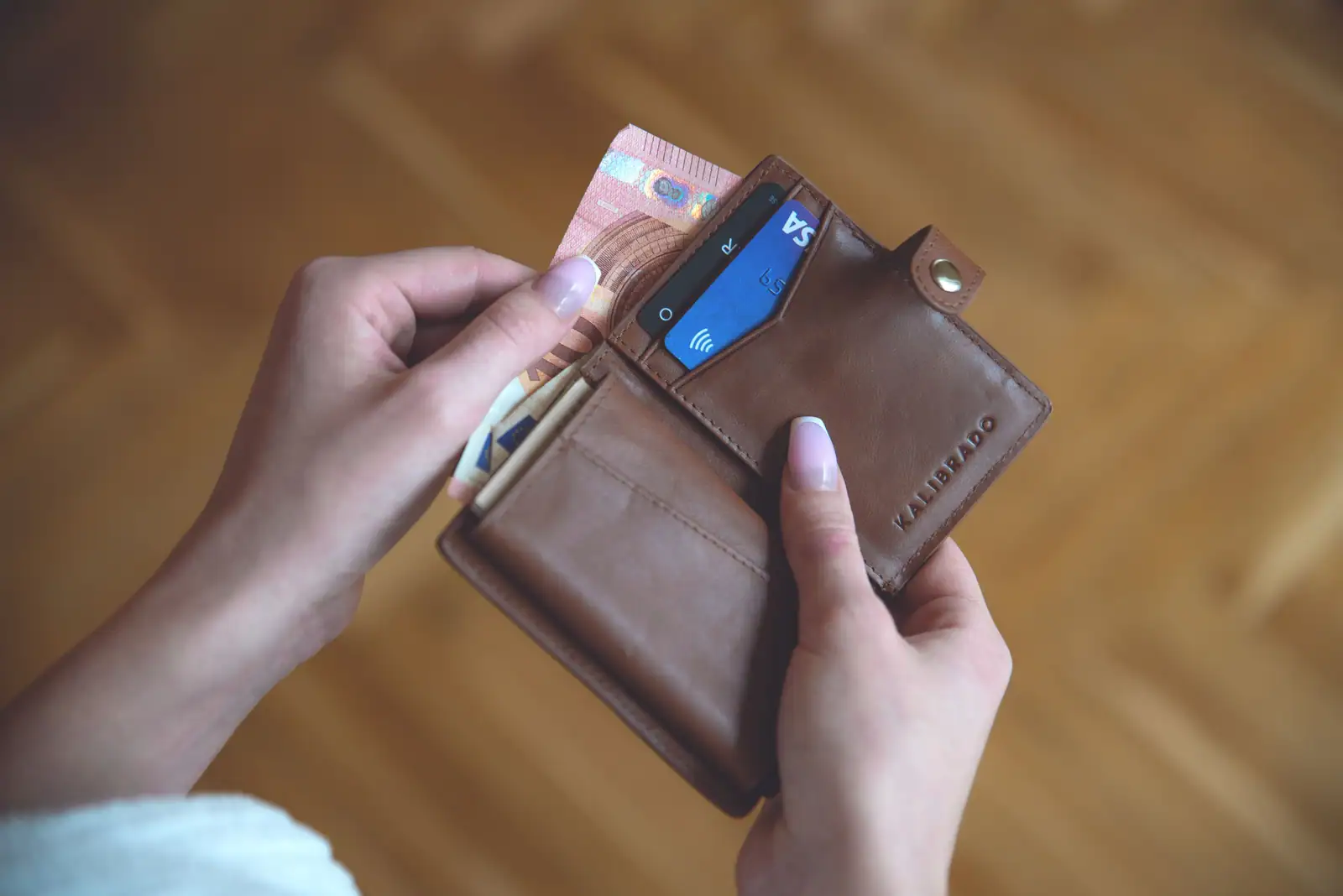 Portefeuille en cuir ouvert avec des billets en euros et une carte bancaire à puce visible